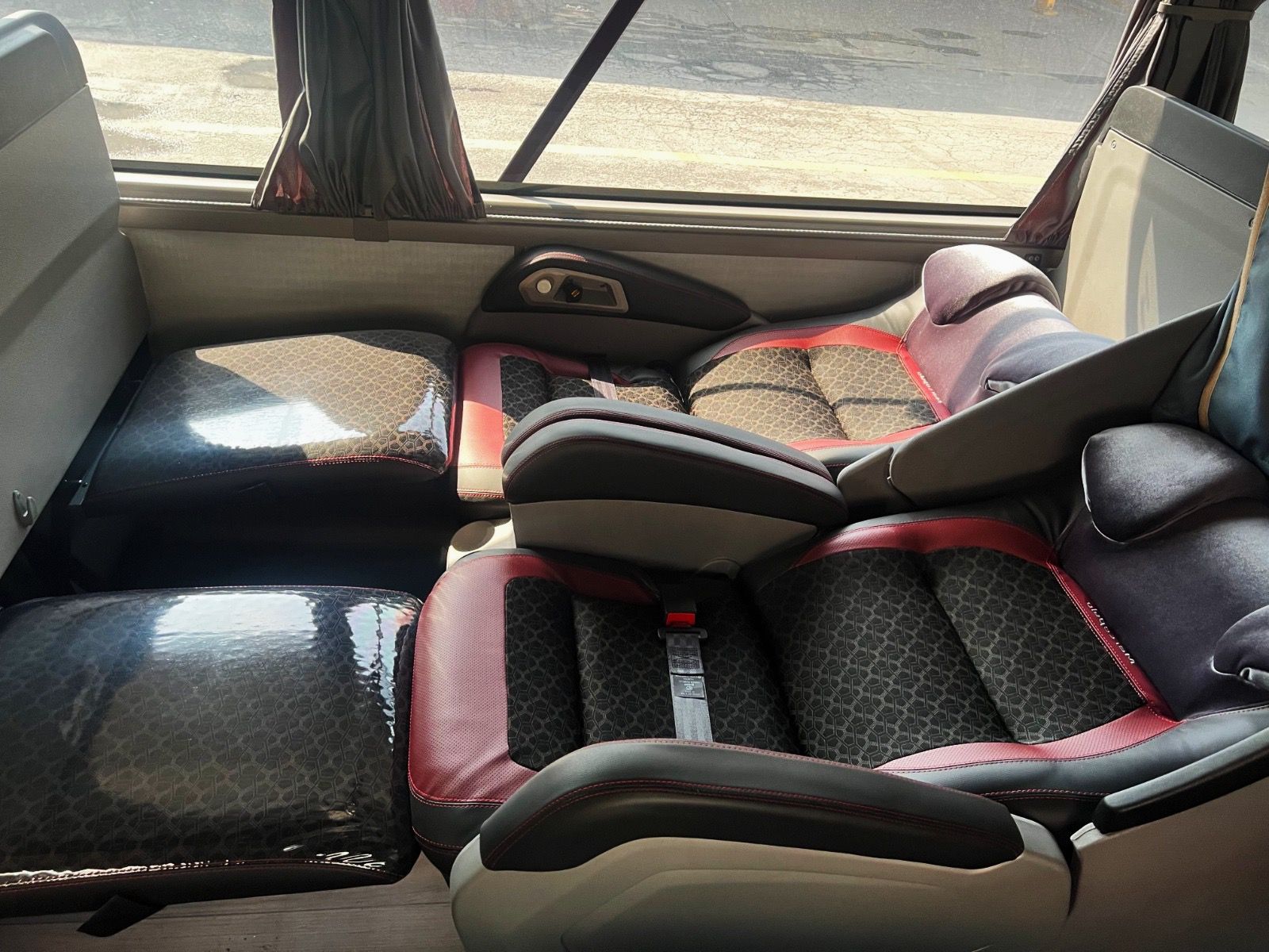 Interior de ônibus com leito cama, cortinas individuais e apoio para pernas - Viagem confortável | Conectar Passagens